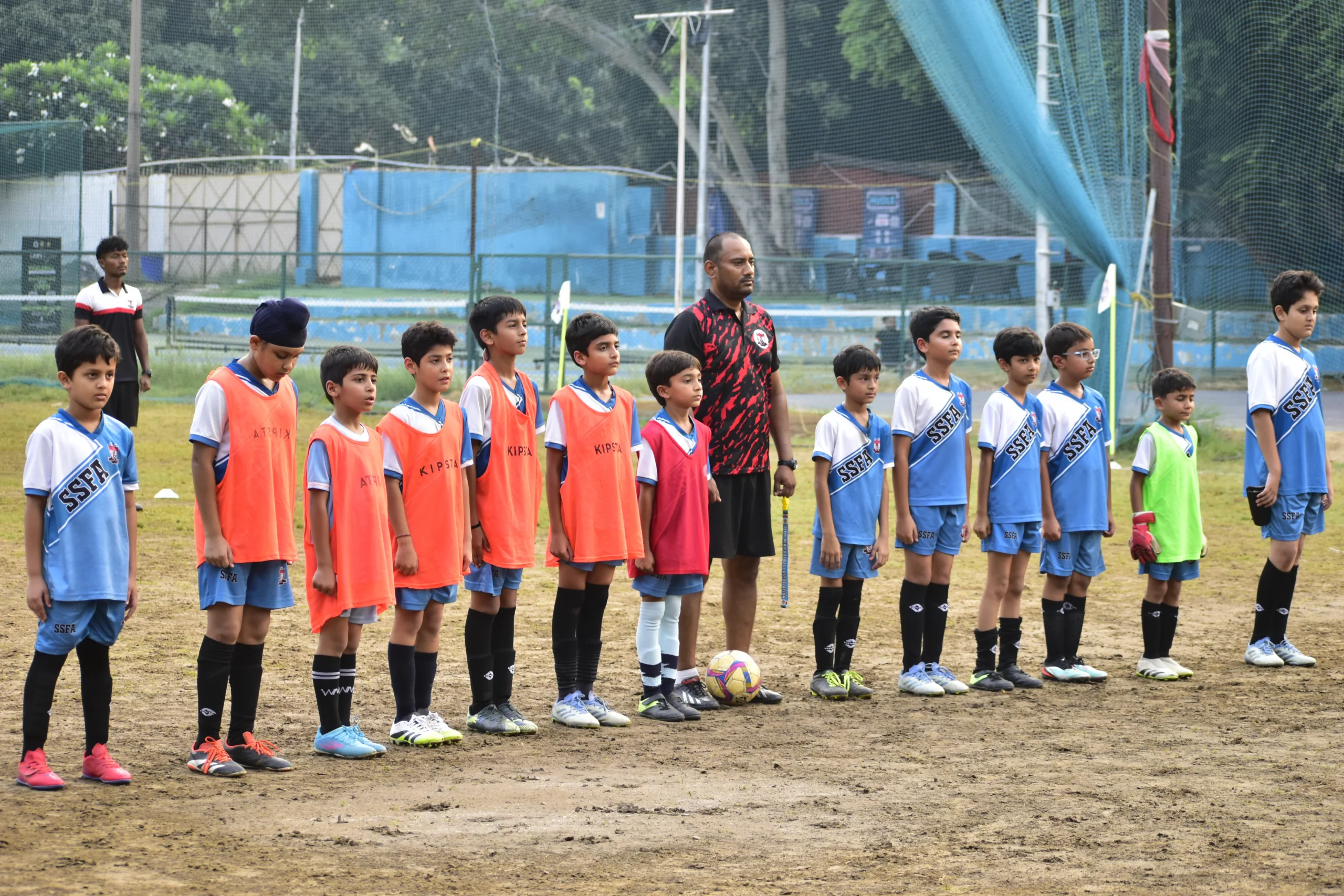 Kids standing for the national anthem before the match at khan market star strikers football academy